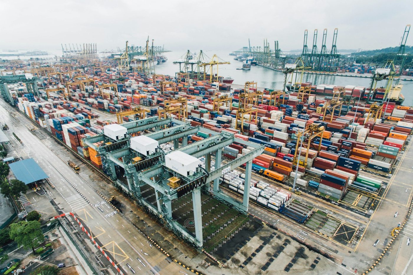 Aerial view of a container terminal with stacked containers and quay cranes